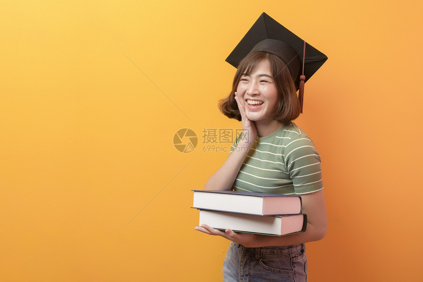 在工作室背景上戴着毕业帽的年轻亚洲学生的肖像在工作室背景上戴着毕业帽的年轻亚洲学生的肖像图片