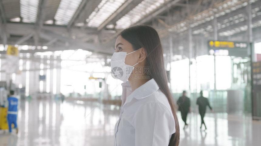 一名商业妇女在国际机场佩戴保护面具在新冠大流行下旅安全社会不和协议新正常旅行概念图片