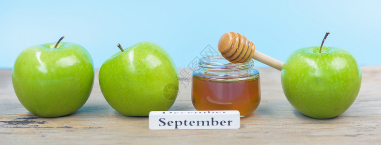 犹太节日照片上的苹果RoshHashhanah在罐子里有蜂蜜图片