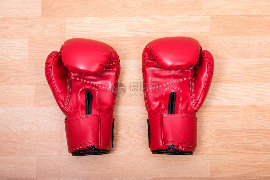 两只红拳手套放在木制桌上图片