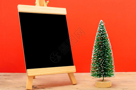 圣诞成像装饰最小绿色fir树枝红底有雪和黑板圣诞快乐概念复制文本空间图片