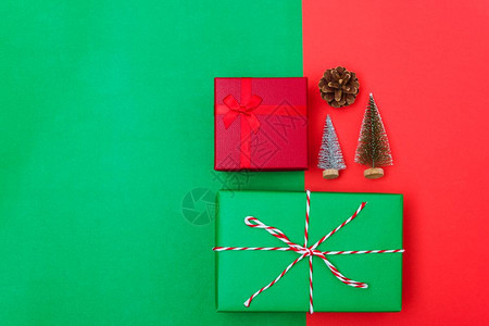 新年圣诞节的构成带有礼品盒的顶端观景绳子的割缝红绿树枝和色背景的树枝以及复制空间背景图片