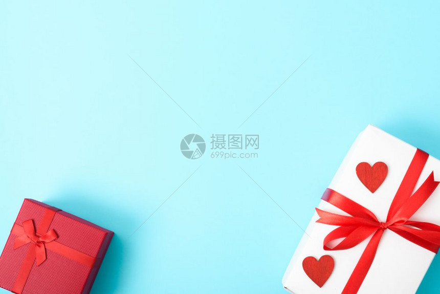 情人节概念顶视平板礼品盒和红心放在蓝背景的色上并附文本的复制空间图片