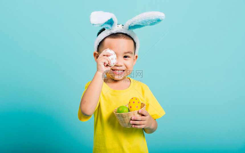 复活节装扮的黄衣男孩蓝色背景图片
