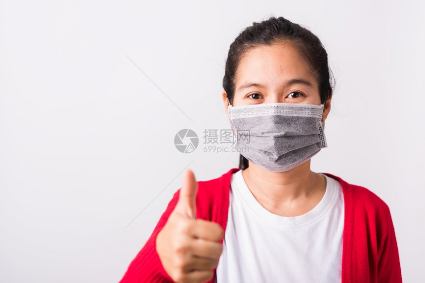 身穿红衬衫和面罩的亚洲成年妇女身穿红衬衫面罩防止冠状或COVID19或过滤灰尘空气污染她展示的指拇以好孤立白种背景图片