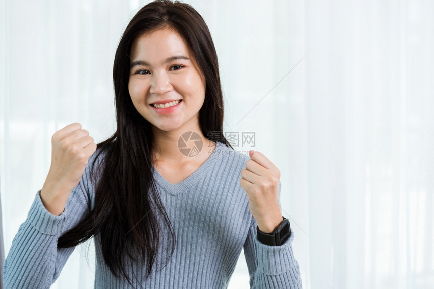 亚洲美丽健康笑脸的亚洲肖像举起手来成功或赢得是的手势工作室拍摄在家里寻找相机图片