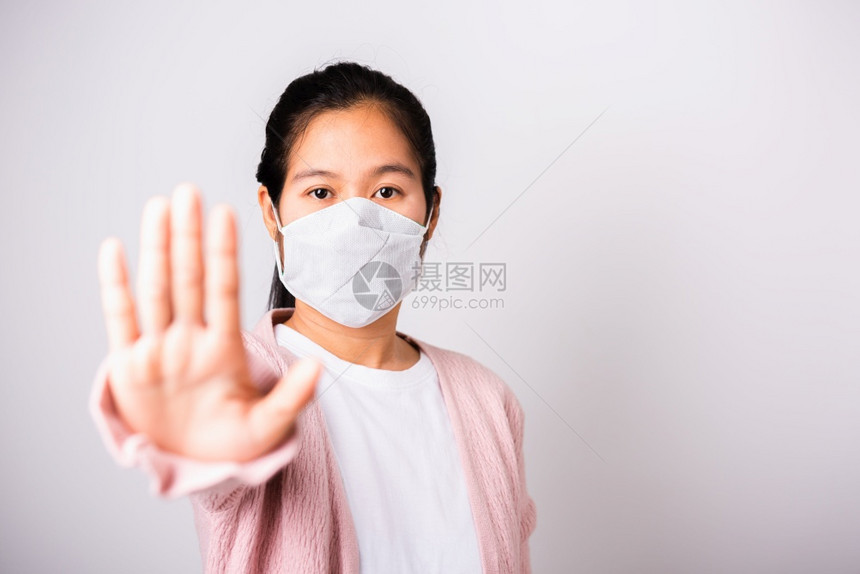 身穿外科保护的亚洲妇女面对冠状的罩卫生她举起手停牌工作室用复制空间COVID19或冠状概念在白色背景上单独拍摄带有复制空间COV图片