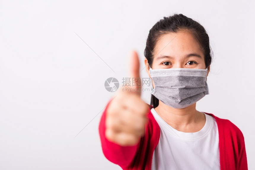 身穿红衬衫和面罩的亚洲成年妇女身穿红衬衫面罩防止冠状或COVID19或过滤灰尘空气污染她展示的指拇以好孤立白种背景图片