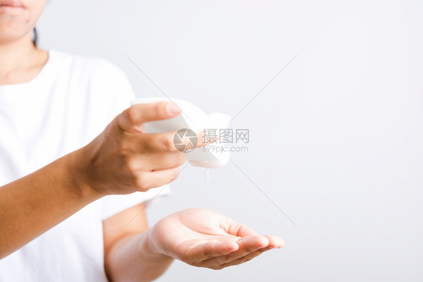 亚洲青年妇女在洗手清洁防卫生COVID19或白底隔离的冠状保护概念上施用滴撒机净化剂酒精凝胶图片