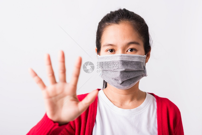 身穿红衬衫和面罩的亚洲成年妇女身穿红衬衫面罩防止冠状或COVID19或过滤灰尘空气污染将手举到没有或停止标志处孤立的白色背景图片