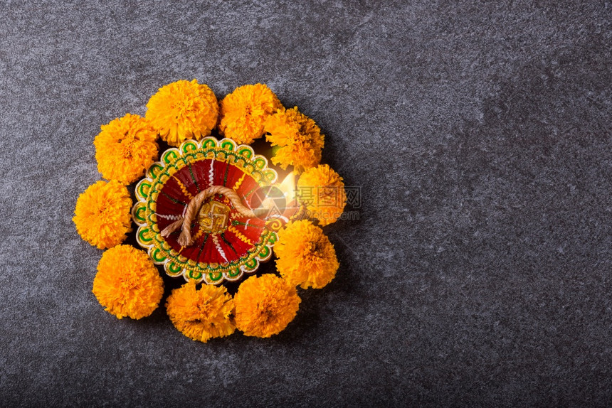 上方的天顶望点亮了Diya或油灯和黄色花朵以混凝土背景拍摄的影棚印度兰焦利教的装饰Deepavali快乐或Diwali节概念图片