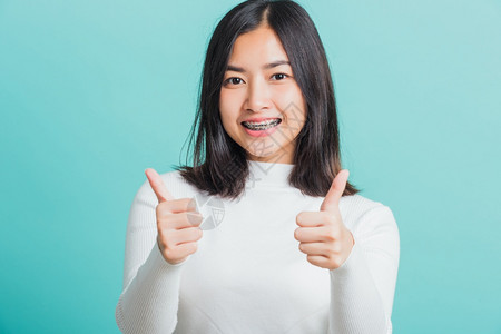 年轻美丽的亚洲女士欢笑的着举起手指拇肖像快乐的女成人高清图片素材