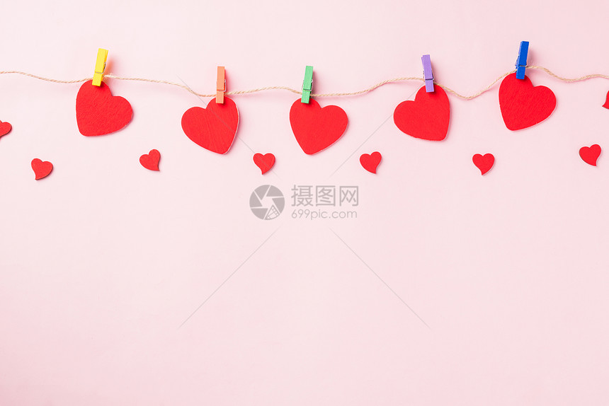 情人节快乐的一天背景红色心形情人节装饰上面挂着纸片在爱的绳索上粉红背景和复制空间上隔开的贺卡图片