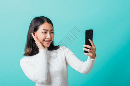 使用智能手机拍摄自通过手机摄快乐的女照片图片