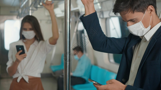 近身商人站在座位上使用现代智能手机在互联网上检查电火车新闻图片