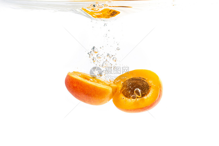 新鲜熟的杏子在清水中被一分为二在清水中被一分为二孤立在白色背景上新鲜熟的杏子在清水中被一分为二在清水中被一分为二图片