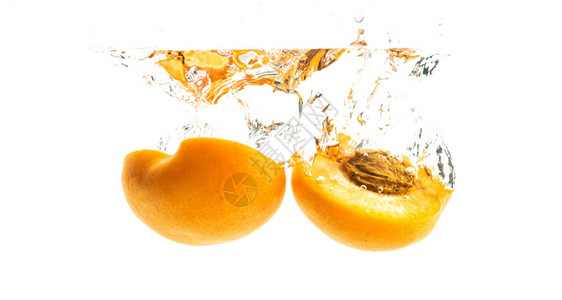 桃子水新鲜成熟的有机杏子在清水中半坠落在白色背景上被孤立新鲜成熟的桃子半坠落在清水中背景