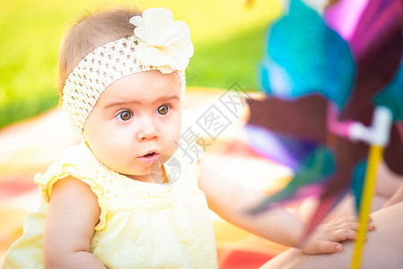 黄色星球可爱的小caucasian女孩与母亲在花园里玩乐的肖像快童年和婴儿保健有丰富多彩的风车婴儿背景