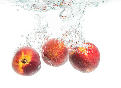 桃子水三个桃子掉入水中喷着背景
