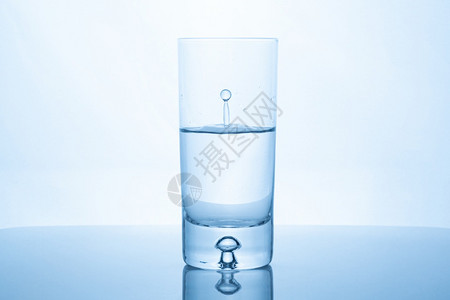 水滴倒在玻璃里一半满的玻璃里纯洁和健康的概念一半满的玻璃图片