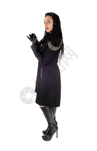 身穿黑色大衣和靴子手套的年轻美女身穿黑色大衣和靴子手套白底隔离图片