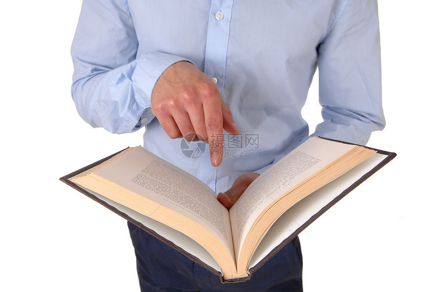 一个站立的年轻男子是一个工作室拿着一本公开的书指着他正在读图片