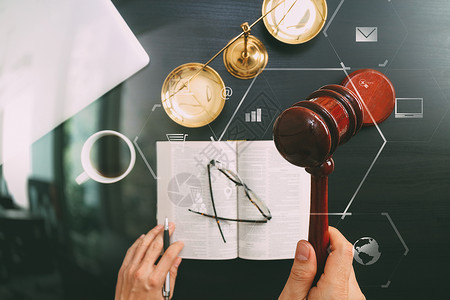 男律师法官正义和法律概念男法官手拿木槌铜秤和电脑在法庭上的俯视图打开深色木桌上的圣经书用Vr图设计图片
