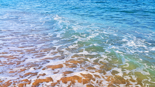 沿海沙砂中含有白泡沫的海水天然封闭背景图片