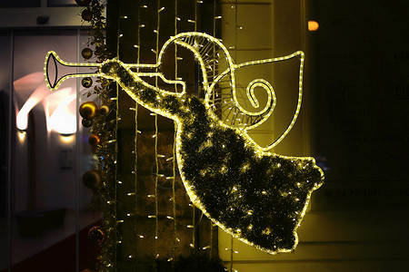 圣诞节发光装饰以抽象的天使形式在捷克布拉格的晚上吹号喇叭图片