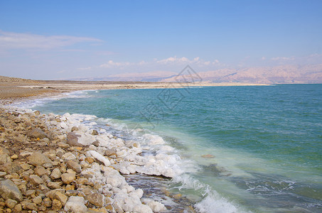 以色列死海岸线与石头上天然矿物形成的前景背景图片