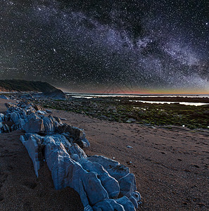 夜间海洋岸从滩看边有大石头天空星状银河法国圣让德卢斯比凯湾背景