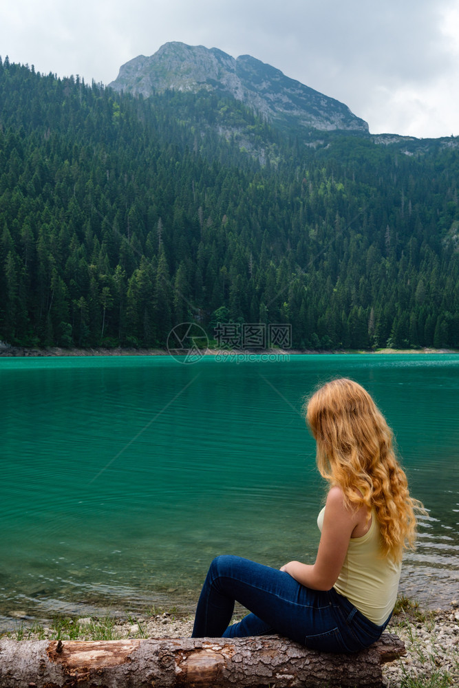 年轻少女在黑山Zabljak市黑湖CrnoJezero海岸夏季风景的树木上休息图片