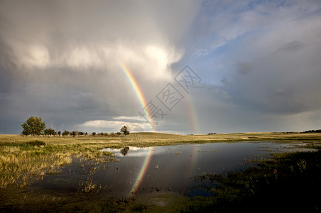 萨斯喀彻温风暴云彩虹反射到水中图片