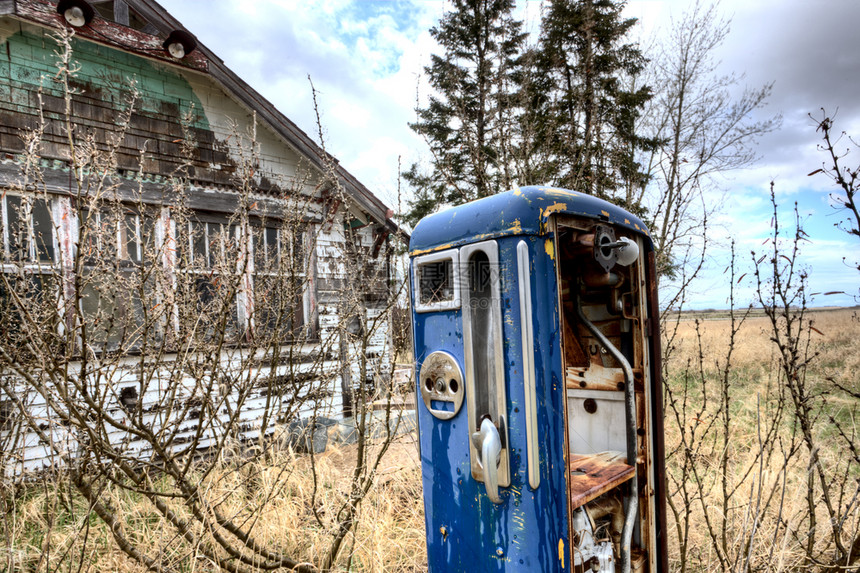 旧式天然气泵和废弃房屋图片