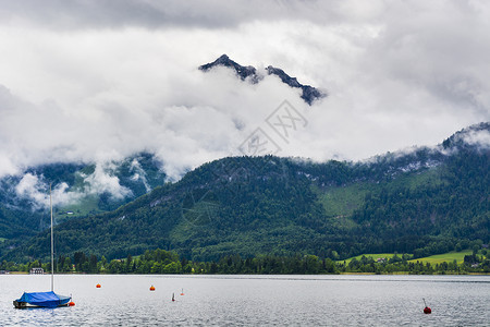 奥地利沃尔夫冈赛的雨和云早上在奥地利风景喷雾湖游艇森林牧场草地和村庄图片