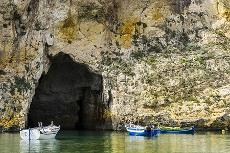 师恩深似海在由纯石灰岩悬崖划定的崎岖海岸线上游艇充满了马耳他的深洞内海是戈佐岛与地中海相连的环礁湖由狭窄的自然拱门形成背景