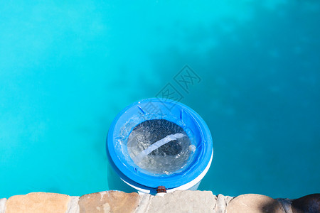 夏季在户外游泳池墙壁附近的塑料水过滤器图片