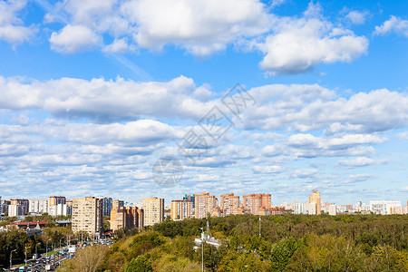 在阳光明媚的秋天在街道和城市公园的蓝色天空中白云图片