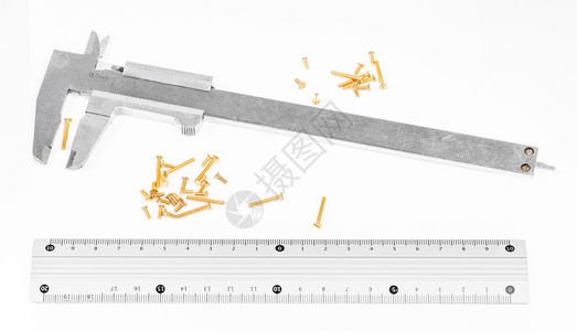旧的钢大口径铁炉金属标尺和许多白底铜螺钉图片