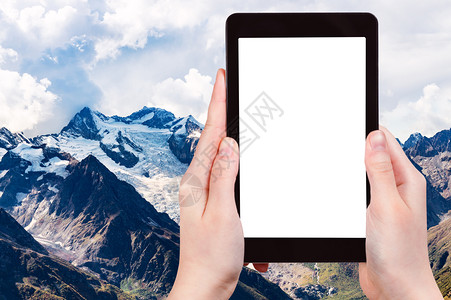 旅行概念俄罗斯Dombay度假胜地MoussaAchitara山雪覆盖的顶旅游照片用智能手机拍摄带空白广告位置的剪切屏幕背景图片