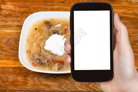 旅行概念俄罗斯菜汤和陶瓷碗中的酸苏和奶油的旅游照片智能手机上剪出带空白广告位置的屏幕背景图片