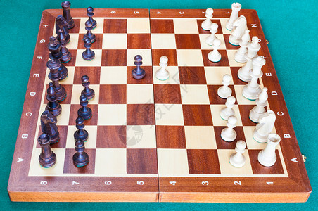 木象棋的侧边视图首个象棋当铺在绿色烤肉桌上移动图片