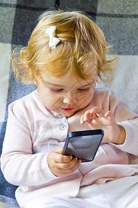 新生女婴儿带手机的高加索可爱小女婴图片