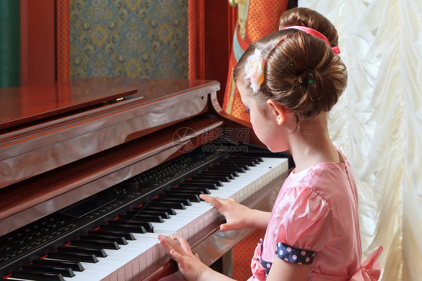 穿粉色衣服的小女孩弹钢琴图片