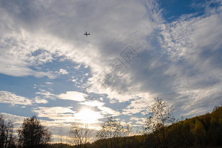 航空在秋天的森林上与美丽的云天空对抗大飞机休眠航班一种图片