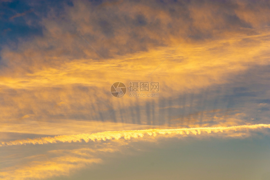 晚上美丽的天空风景有明亮的金色云彩和阳光束黄色的图片