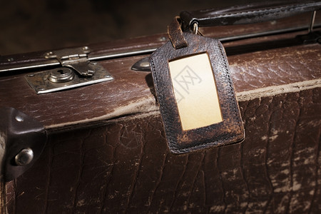 细节目的古董旧棕色行李箱上的旧标签图片