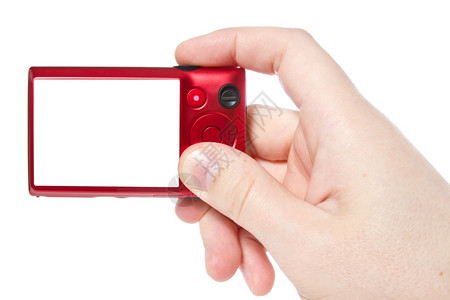 屏幕展示白色的背景上隔离的数码照相机用红色双手与数码照片相机图片