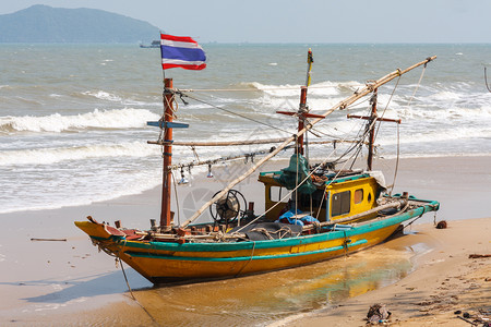 洗过岸上粗糙的泰国渔船搁浅在海滩上的渔船图片