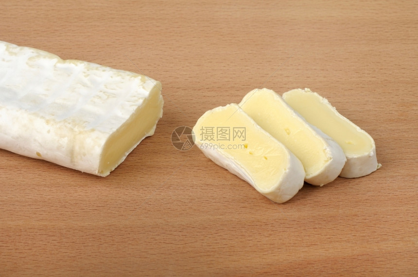 营养木制背景的切片白芝士色的布里干酪图片